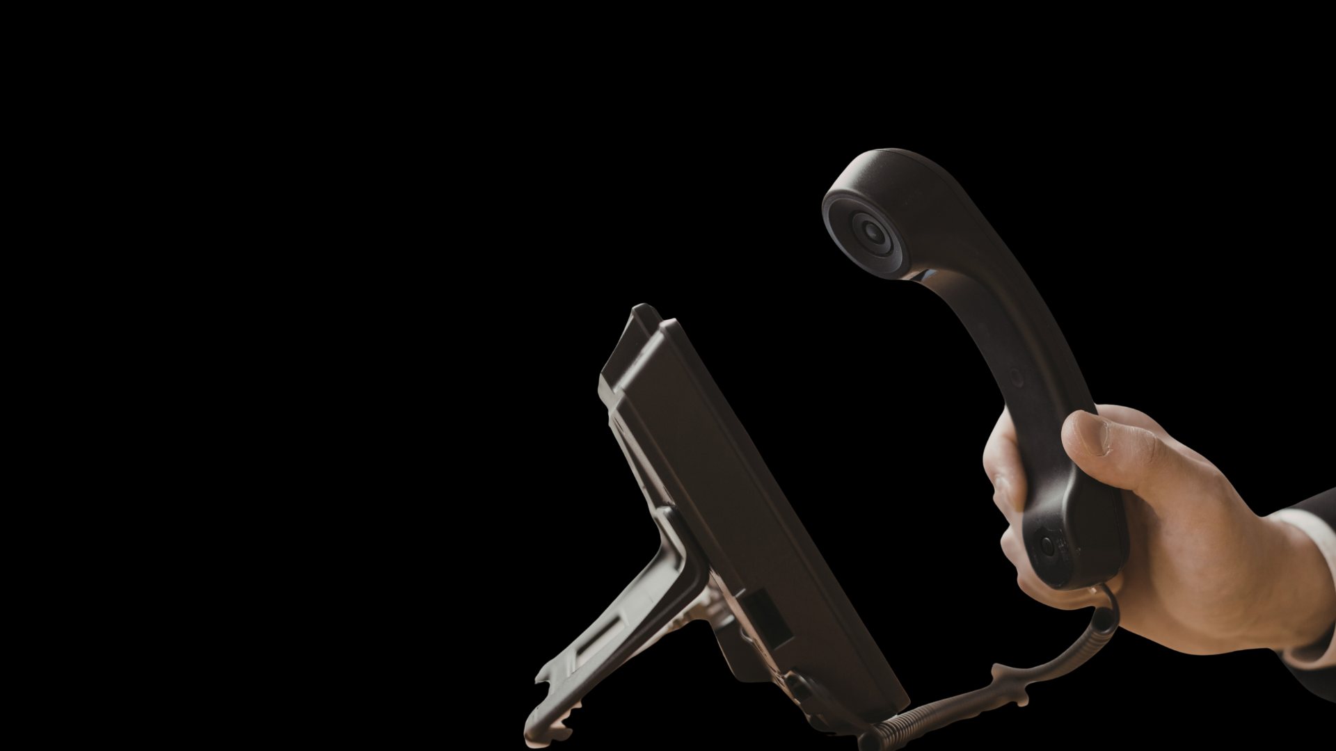 Mão segurando o fone de um telefone IP de mesa